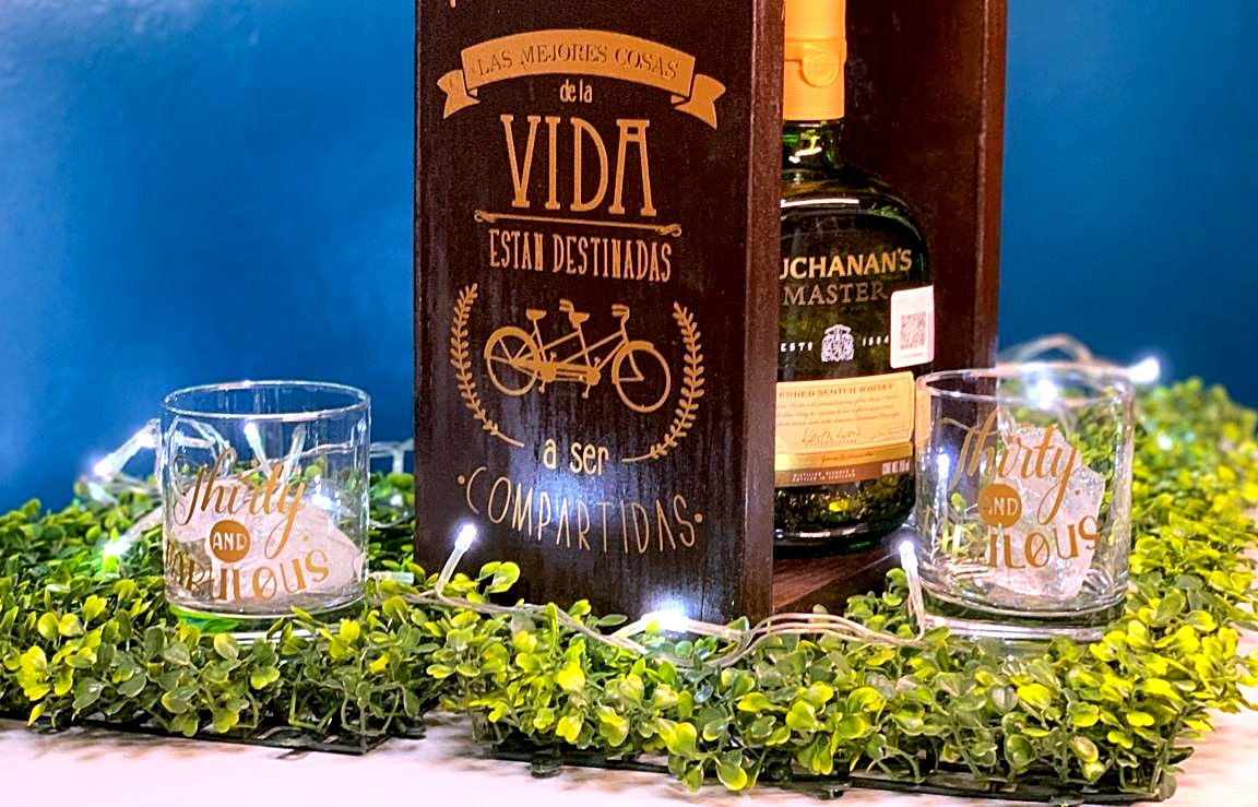 Caja de madera grabada con una frase, whisky y dos vasos grabados