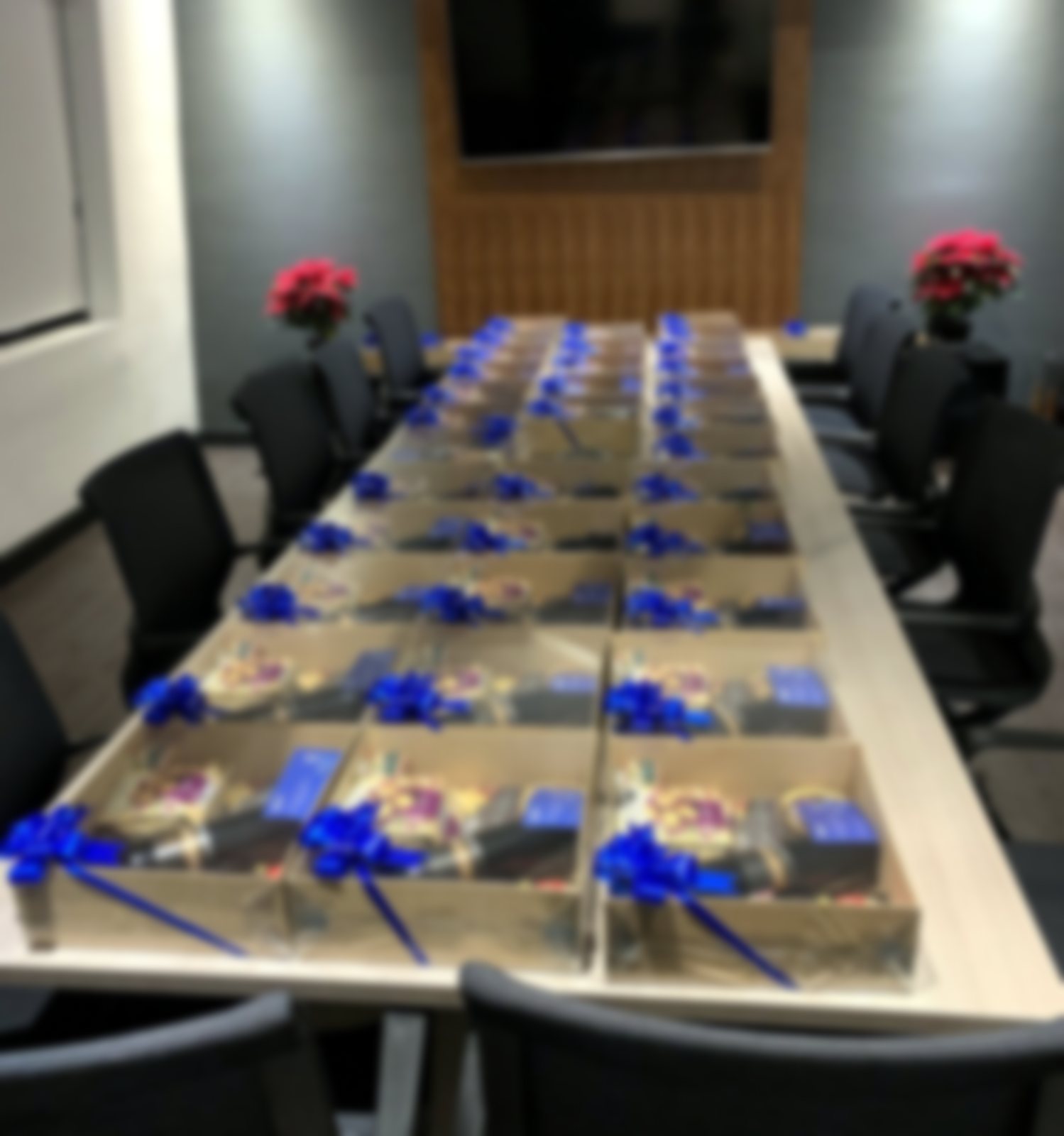 Sala de juntas con decenas de kits de regalo con moño azul listos para entregar